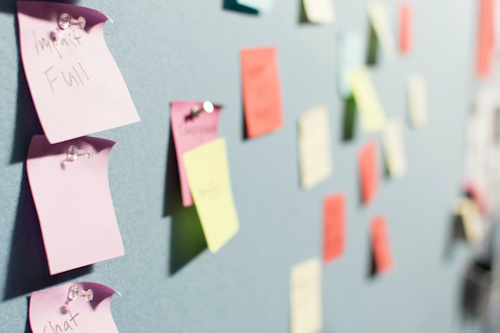 Multi-colored Post-it notes on a grey background.